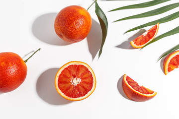 Composition of Sicilian oranges, whole and cut on a white background.