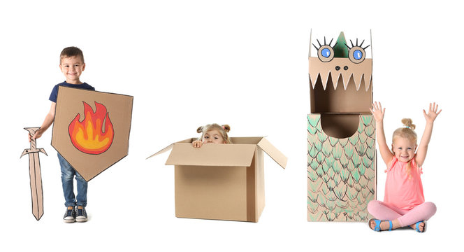 Little cute children playing with cardboard boxes on white background. Handmade toys and costumes