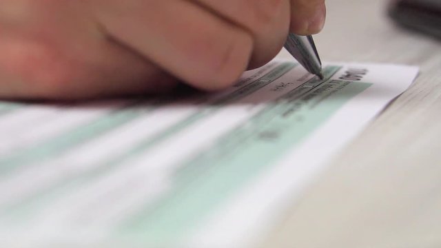 Closeup video of woman filling tax form 1040 aon the desk next to computer keyboard and calculator. 4k video