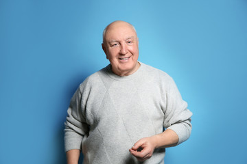Portrait of elderly man on color background