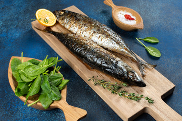 Baked mackerel fish on blue background, top view
