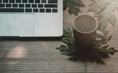 Laptop on a wooden table and a cup of coffee - Image