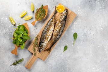 Baked mackerel fish on gray concrete background, top view