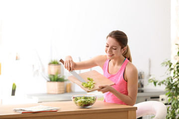 Young woman in fitness clothes preparing healthy breakfast at home