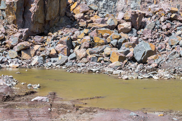 Spectacular view of quarry open pit mining of granite stone. Process production stone and gravel. Groundwater in the quarry.