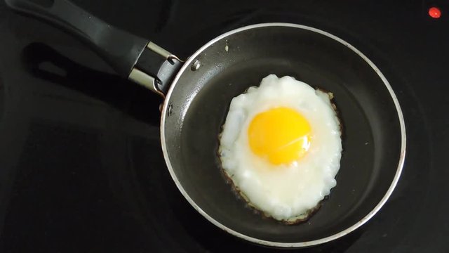 Egg is fried in a skillet. Cooking breakfast.