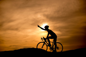 Silhouette cyclist at sunset.