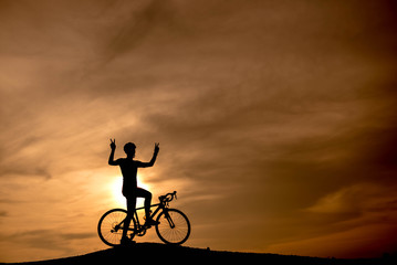 Silhouette cyclist at sunset.