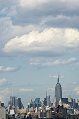 Obraz premium A sweeping view of New York City's midtown Manhattan with some of its iconic buildings, skyscrapers and structures, from the vantage point of Brooklyn Bridge.