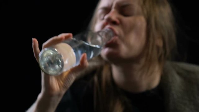 Poor addicted woman greedily drinking alcoholic drink from bottle, ugliness