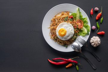 Asian dish fried noodles with egg and seafood or beef or chicken