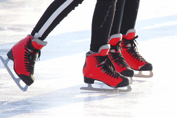 Naklejka premium feet in red skates on an ice rink