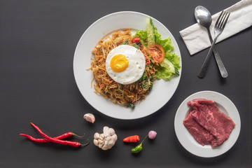 Asian dish fried noodles with egg and seafood or beef or chicken