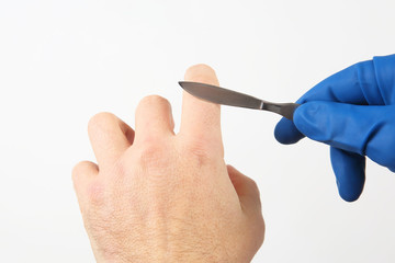 gloved hand with medical scalpel on white background