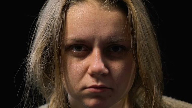 Girl with indifferent empty stare looking into camera, hospital for mentally ill