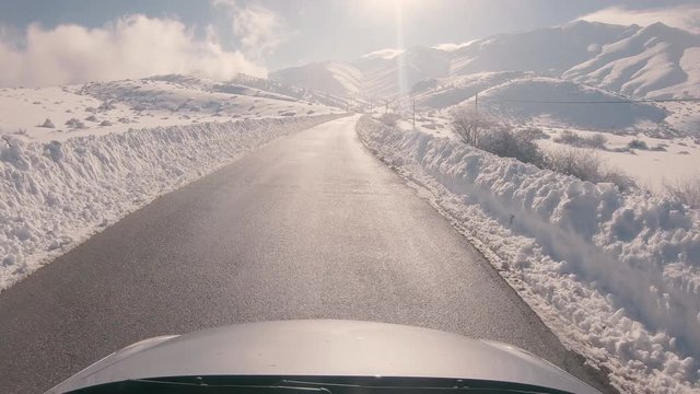 Driving on a snowy mountain road, sunny weather. Approaching Ziria ski center in Greece.