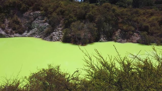 Pan left across green thermal "Devils Bath" pool at Wai-o-Tapu, Rotorua, New Zealand. 4k