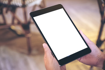 Mockup image of a woman holding black tablet pc with blank white screen while sitting in cafe