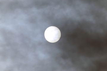 solar disk at noon through the clouds