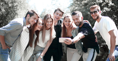 group of friends takes a selfie on the background of the city Park