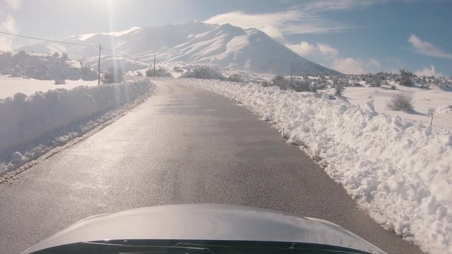Driving on a snowy mountain road, sunny weather. Approaching Ziria ski center in Greece.