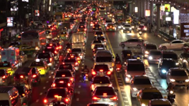 BANGKOK,  THAILAND - CIRCA OCTOBER 2018 : Blurred view of HEAVY RUSH HOUR TRAFFIC JAM near CHIT LOM train station.  Many CAR, BUS, TAXI, MOTORBIKE and TUK TUK on the road.