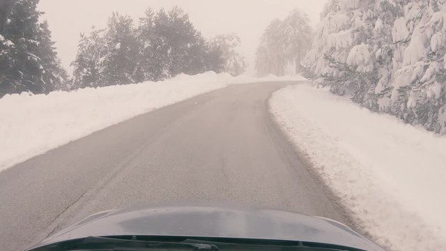 Driving through the fog on a snowy mountain road to Ziria ski center in Greece.