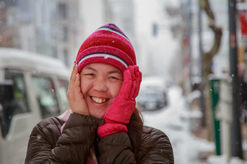 Beautiful and happy young Asia Chinese girl in winter snowy day outdoors - Winter Holiday Concept
