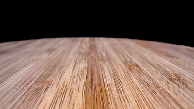 Bamboo cutting board extreme closeup dolly from back to front with hole in board