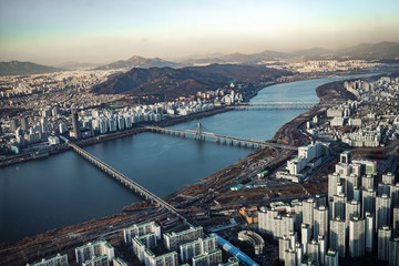 Obraz premium Aerial view cityscape of Seoul, South Korea. Aerial View Lotte tower at Jamsil. View of Seoul with river and mountain. Seoul downtown city skyline, Aerial view of Seoul