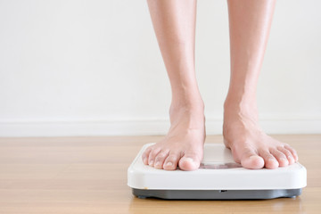 Fototapeta premium Legs of men standing on scales weight. Concept of health and weight loss.