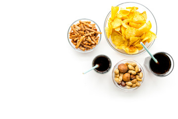 Snacks for TV watching. Chips, nuts, soda, rusks on white background top view space for text