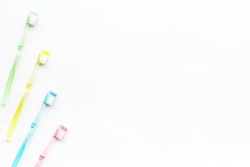 Clean teeth. Colorful plastic toothbrushes on white background top view space for text