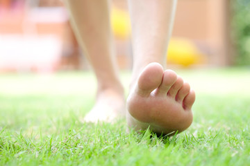 Naklejka premium Leg of woman is on the ground. She is about to walk down the grass to exercise in the morning. Health and Relaxation Concepts