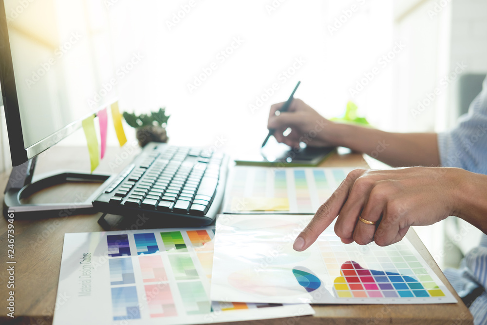 Aufkleber designer editor at work drawing sketches a new project on graphic tablet and color palette sitting a