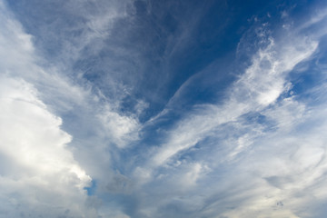 White cirrus clouds in the blue sky on a clear day in the summer. Used as a background image.