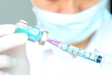 Hand of doctor holding syringe and medicine bottle. Preparing for injection