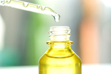 Dropping serum collagen moisturizer of face into clear yellow bottle soft light background. Protector skin Treatment facial essence oil, Vitamin C. Beauty and spa Concept.