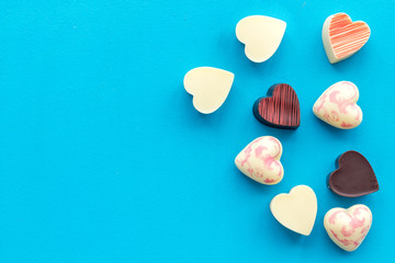 Fototapeta premium Heart-shaped confection for Valentine's day on blue background top view space for text