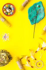 Buddhism attributes and symbols on yellow background top view copy space frame