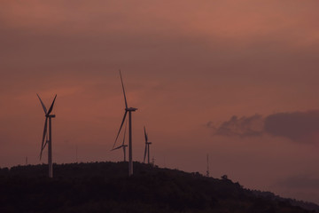 Silhouette of wind turbines generating electricity on the mountain.