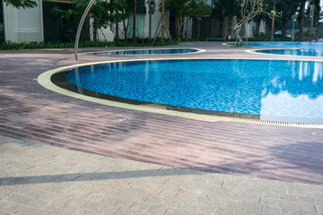Blue swimming pool with wood flooring stripes
