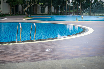 Blue swimming pool with wood flooring stripes