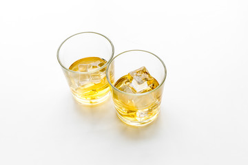 Glass of whiskey with ice on white background top view space for text