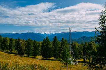 Telecommunication cell tower in the wild forest with mountain background, Altay