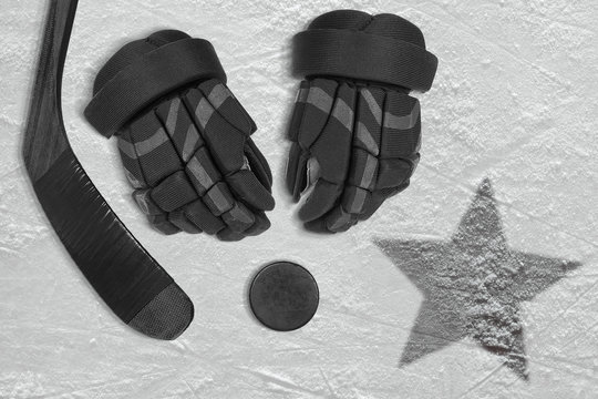 An image of a black star on ice and hockey accessories