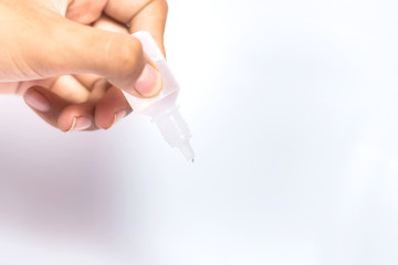 Man holding and droping eye dropper on white background