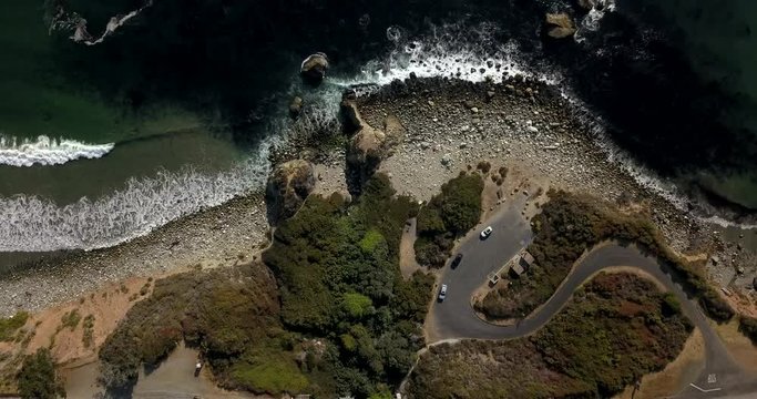 Aerial shot of costal highway rest stop - birds eye view moving towards beautiful ocean