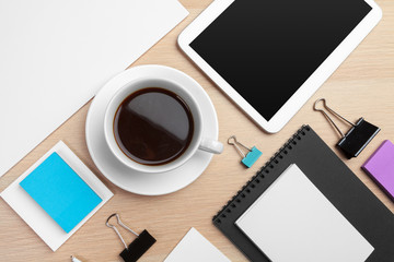 Fototapeta na wymiar Digital tablet with notepad, supplies and coffee cup on desktop.