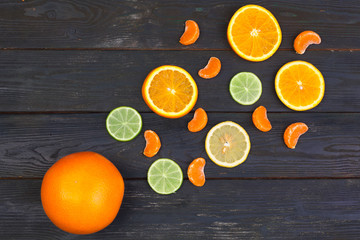 Bright composition of citrus fruits on black wooden background